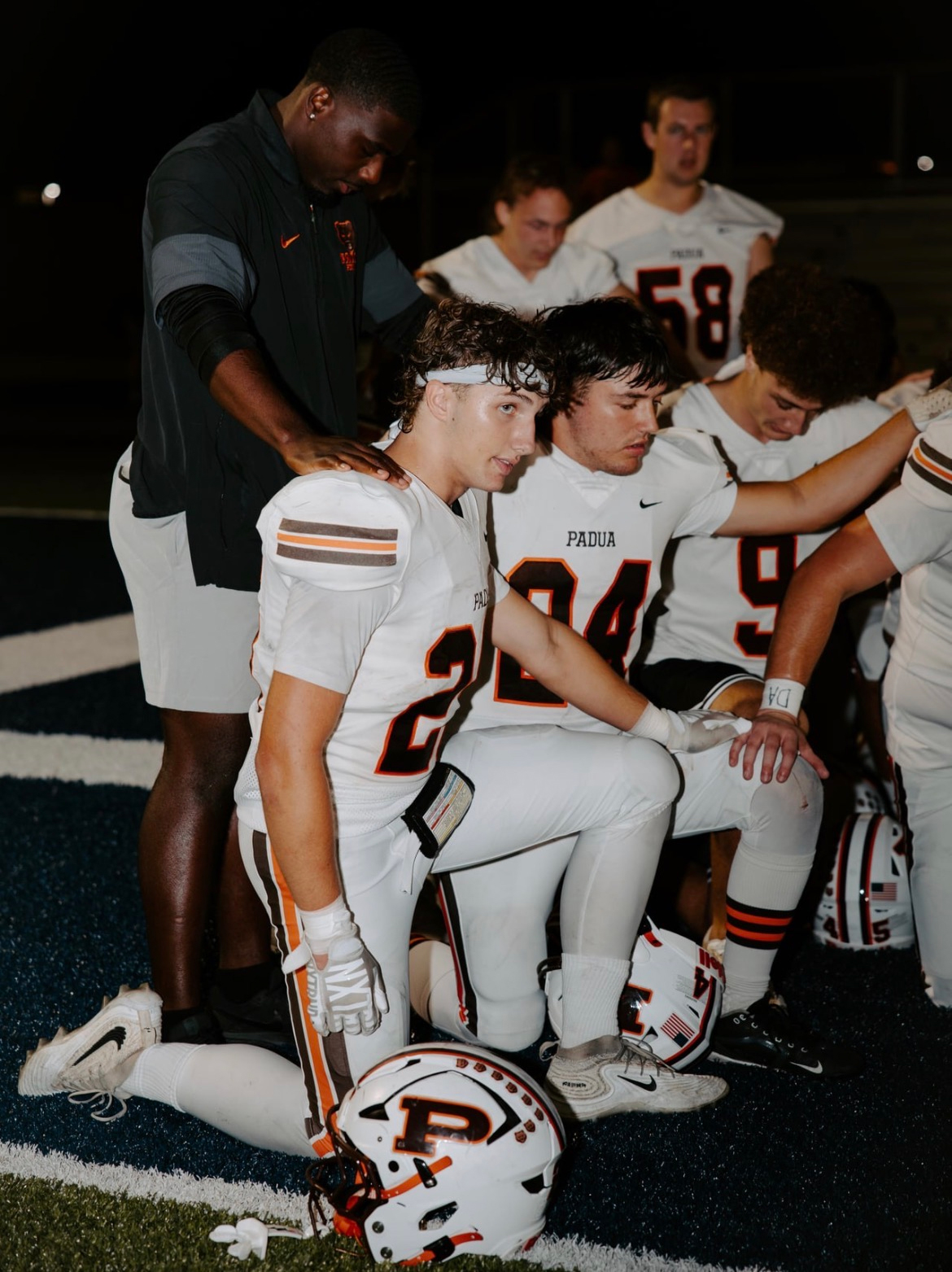 Maks Karasek #25 takes a knee with teammates